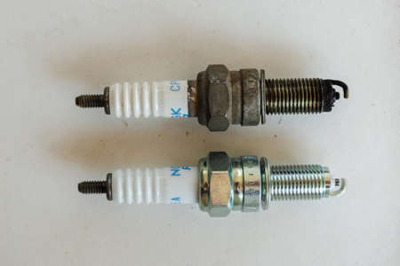 spark plug compare with new and old on white table