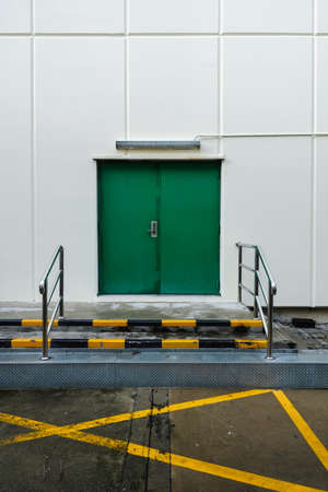 Fire exit door for emergency at outside of white building for safety of people