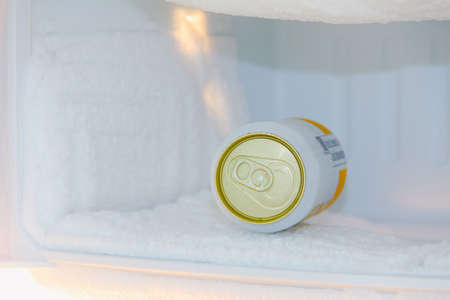 cans of beer were immersed in the freezer of the refrigerator, where the ice was very thickの写真素材