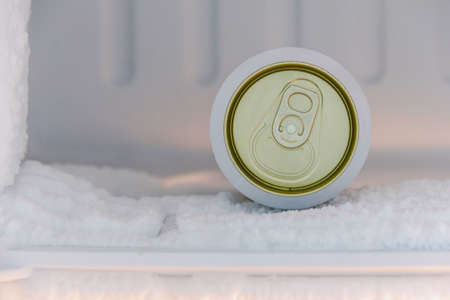 cans of beer were immersed in the freezer of the refrigerator, where the ice was very thickの写真素材