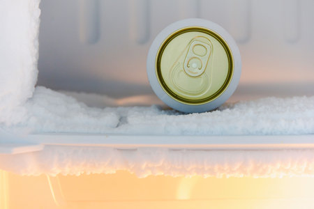 cans of beer were immersed in the freezer of the refrigerator, where the ice was very thickの写真素材