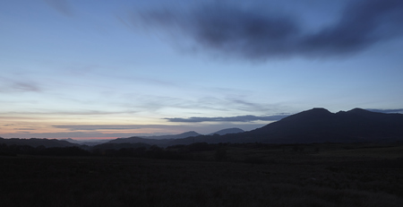 Silhouettes of Snowdonia mountains in North Wales just after sunset.の写真素材