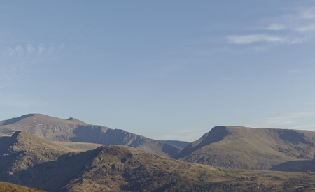 Summits of Snowdon mountain range on a clear day. Snowdon mountain railway line can be seen on the side of the mountain.の写真素材
