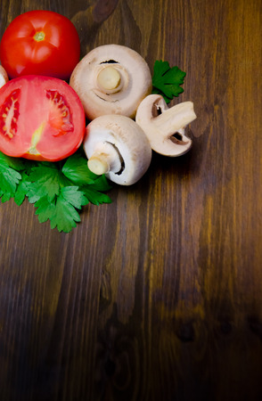 mushrooms mushrooms with parsley and tomatoes on wooden background selective focusの写真素材
