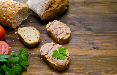 bread and sandwiches with pate and tomatoes on wooden background selective focus