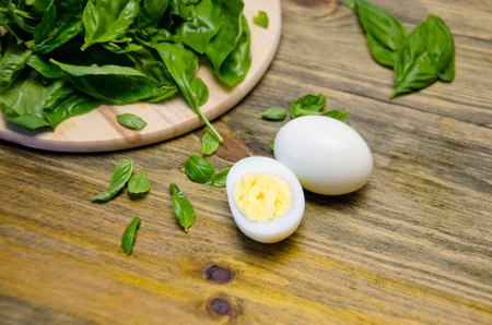 boiled eggs and Basil leaves on wooden background selective focusの写真素材