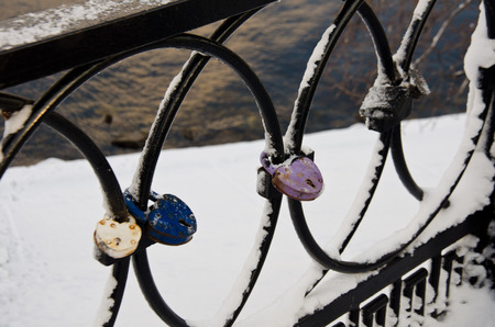 locks on fence in winter snowの写真素材