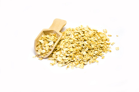 oatmeal grits and wooden scoop with oatmeal on white background selective focus