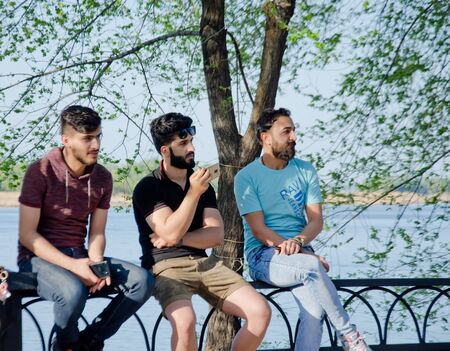 Young men sit and shoot on the phoneのeditorial素材