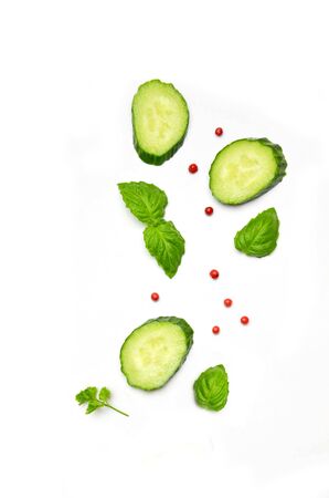 cucumber slice next to Basil leaves and pepper on a white backgroundの写真素材