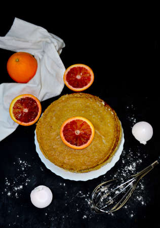 pancakes in a plate next to an orange egg shell on a black backgroundの写真素材