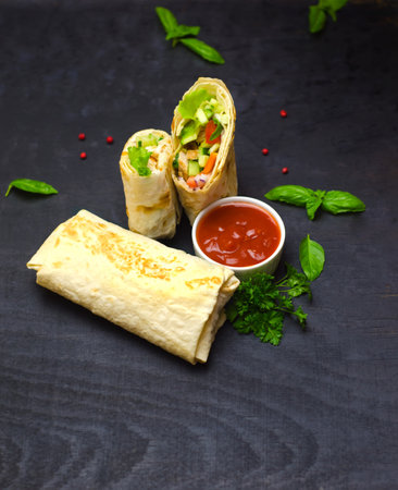 Pancakes with meat, vegetables and sauce on a black backgroundの写真素材