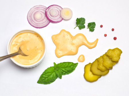 Homemade mayonnaise sauce and ingredients on a white background.の写真素材