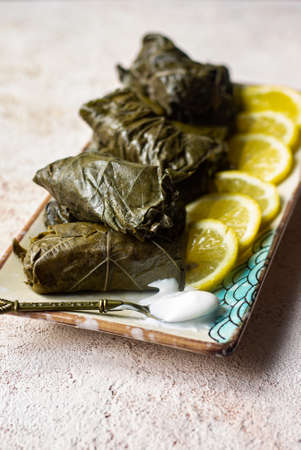 Dolma with lemon and sour cream. Closeup food photography.の写真素材