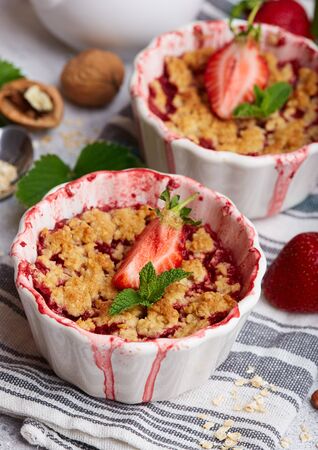 Crumble pie with strawberries. Delicious portion sweet dessert with oat and nutsの写真素材