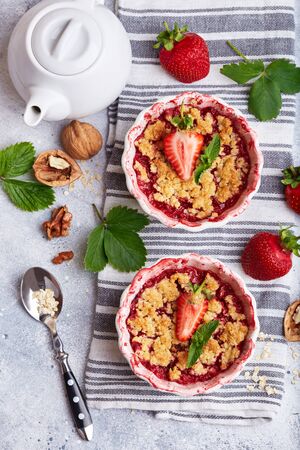Crumble pie with strawberries. Delicious portion sweet dessert with oat and nutsの写真素材