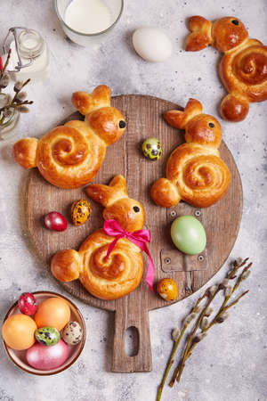Buns made from yeast dough in a shape of Easter bunny, and colored eggs. Traditional Easter symbols...