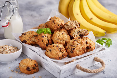 Cookies with oat flakes, bananas and chocolate. Delicious homemade biscuits served with milk.の写真素材