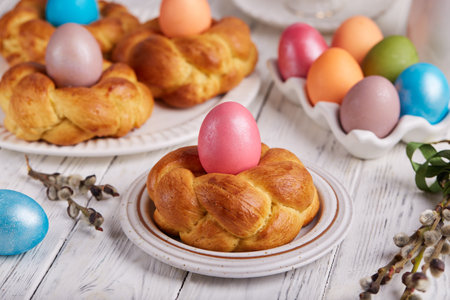 Traditional Easter bun bread in a shape of wreath made from yeast dough decorated with colored egg....