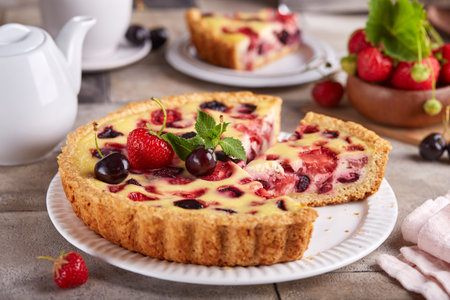 Tart with cherries strawberries and custard milk cream filling. Open cheesecake pie. Delicious homemade summer dessert with berries.の写真素材
