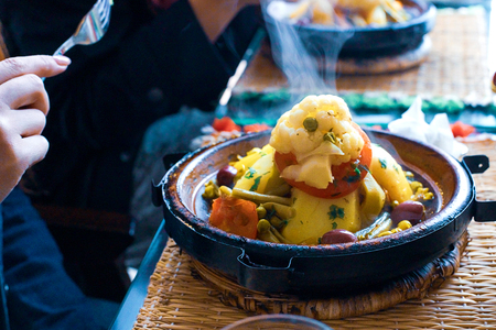 Slow-cooked chicken with prunes, almonds, onions and sprinkled with sesame, Moroccan tagine, rustic styleの写真素材