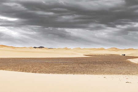 Beautiful sand dunes at sunrise in the Sahara Desert. The sun's rays make their way through the clouds, Moroccoの写真素材
