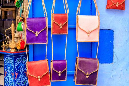 CHEFCHAOUEN, MOROCCO - APRIL 24, 2019: Colorful Moroccan fabrics and handmade souvenirs on the street in the blue city Chefchaouen, Morocco, Africa.の写真素材