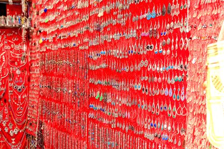 A selection of earrings, jewelry on a red background on the market in Morocco. 24/04/2019の写真素材