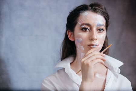 Creative fashion beauty portrait of a beautiful young woman with an artistic tassel in her hands....