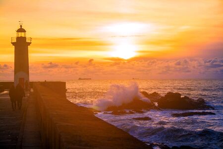 Felgueiras Lighthouse on shore of Atlantic ocean in Porto, Portugal at sunset.の写真素材