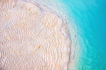 View of natural terraces in Pamukkale on a summer day. Close-up texture of limestone and water flowing over it.の写真素材