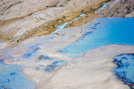 View of natural terraces in Pamukkale on a summer day. Close-up texture of limestone and water flowing over it.の写真素材