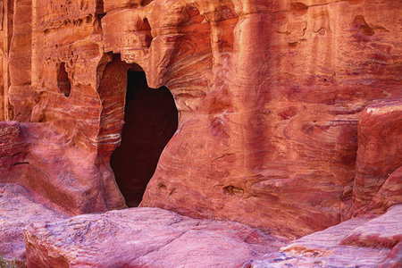View of the wall with the door, the entrance to the temple, carved into the red sandstone rock in the canyon. Petra, Jordanの写真素材
