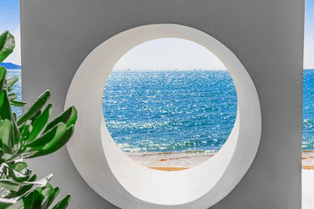 Beach at Worlds End Park, Sanya, China. View of a beautiful and sea through a round hole in a wall.