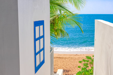 View of the decoration of the white chapel, which stands in the shade of a palm tree on the seashoreの写真素材