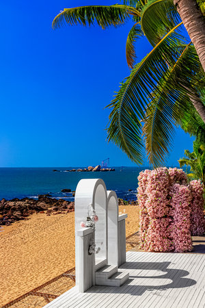 View of the beautiful white wedding arch, which is located on the shore of the blue sea. Sanya Chinaの写真素材