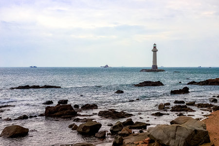 View of the lighthouse in the sea near the rocky shore. Heavenly Grottoes Park, Sanya, Chinaの写真素材