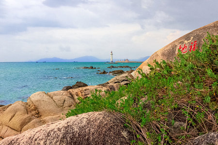 View of the lighthouse in the sea near the rocky shore. Heavenly Grottoes Park, Sanya, Chinaの写真素材