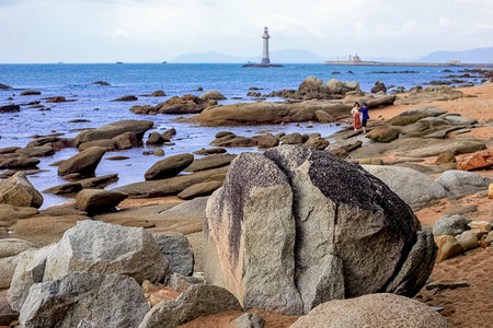 View of the lighthouse in the sea near the rocky shore. Heavenly Grottoes Park, Sanya, Chinaの写真素材