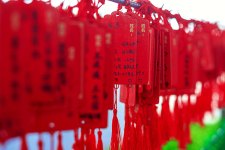 Wooden signs with Chinese characters and dragon designs, decorated with bright red tasselsの写真素材