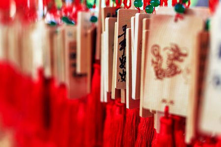 Wooden signs with Chinese characters and dragon designs, decorated with bright red tasselsの写真素材