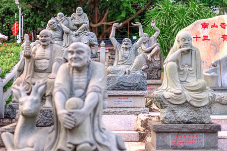 Stone sculptures of Buddhist monks in Nanshan Park, China. General view, daytime, summerの写真素材