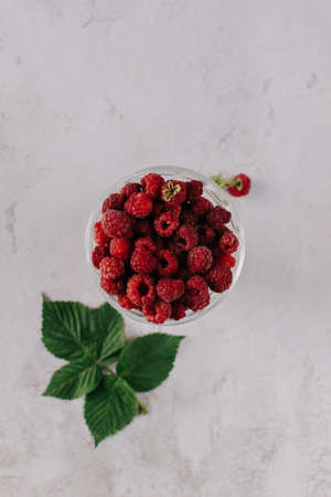 Fresh raspberry in glass vase flatlay