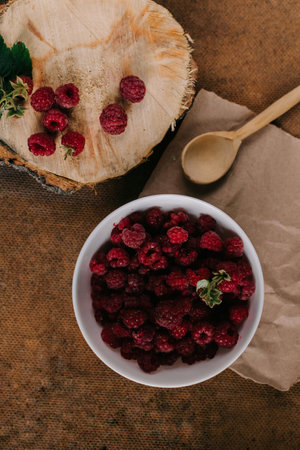 Fresh raspberries in glass vase on wooden background Flatlayの写真素材