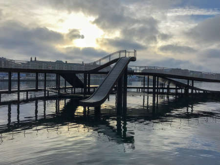 View to the walkway bridge on the South Harbour in Copenhagen under the cloudy skyの写真素材