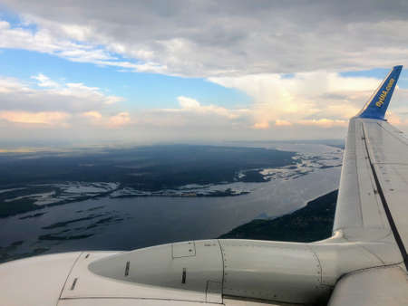 Aerial view of the wing of a passenger plane flying in the clouds.