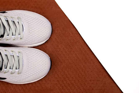 White sneakers on a brown background. Mens sneakers on a white background. Gray sneakers