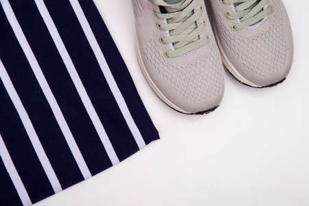 Sneakers on a striped background. Childrens fashion shoes on a black and white striped background....