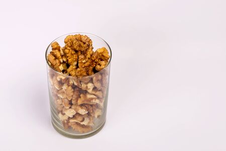A glass of walnuts. Peeled nuts on a white background.の写真素材