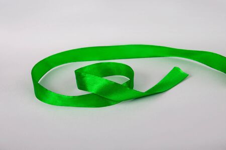 Green ribbon on a gray background. Ribbon for gymnastics. Ribbon for giftの写真素材